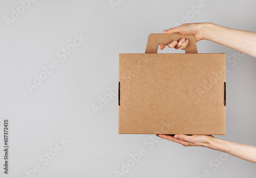 Woman hands holding cardboard box from natural recyclable materials. Responsible consumption, eco friendly packaging, zero waste and sustainable lifestyle concept. © juliasudnitskaya