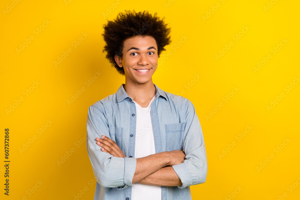 Photo of charming confident guy dressed denim shirt smiling arms crossed isolated yellow color background Photo of charming confident guy dressed denim shirt smiling arms crossed isolated yellow color background