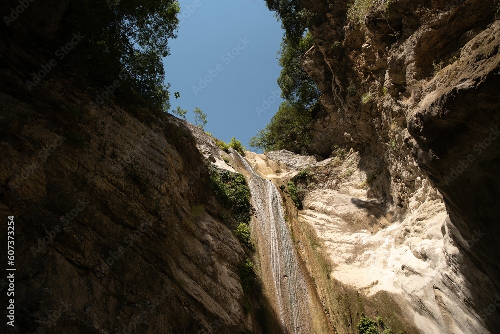 Low-angle of Dimosari waterfalls on Lefkada island sunlit clear sky background