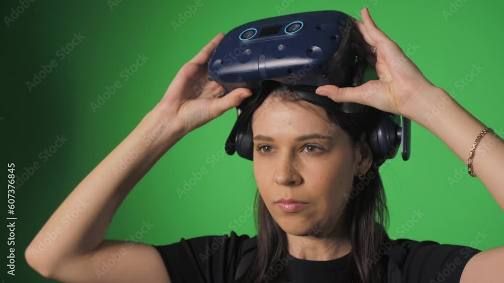 A happy girl lifts virtual reality glasses from her eyes and smiles. A happy girl lifts virtual reality glasses from her eyes and smiles.
