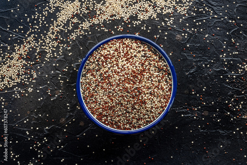 Quinoa mix. Mixed white, red and black quinoa seeds in a bowl, overhead flat lay shot on a black background