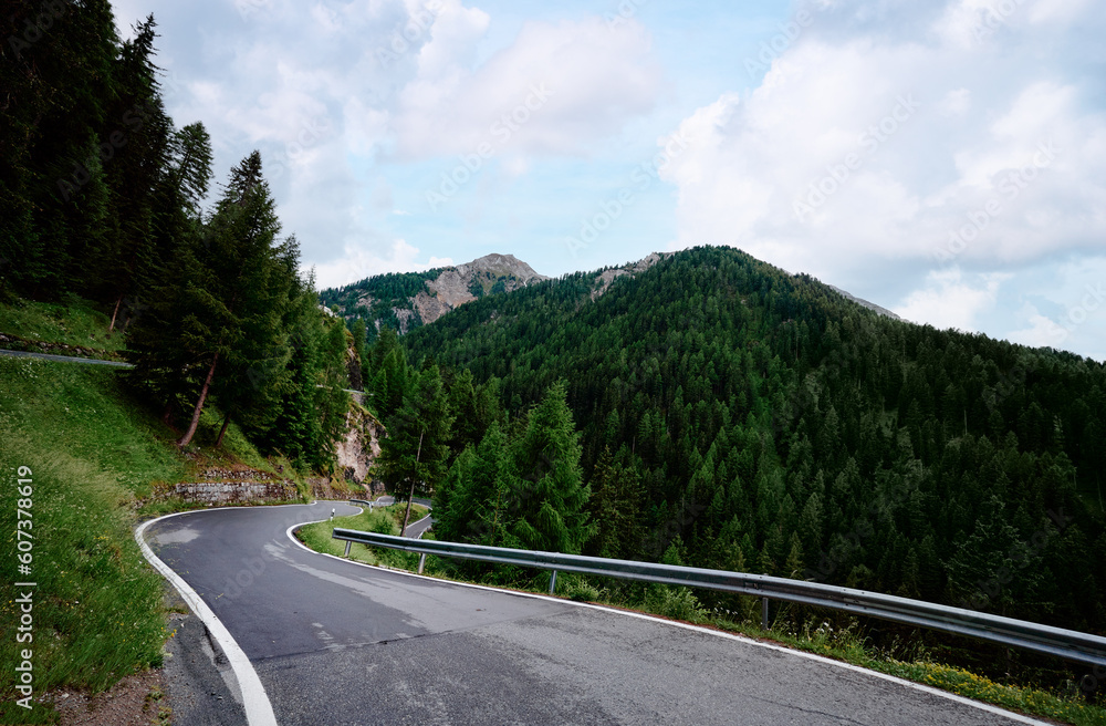 Asphalt road in Alps mountains forest. Road trip concept. Beautiful landscape.