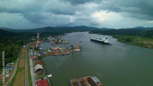 Dark rain clouds rolling over port and cargo ship passing through Panama Canal photo