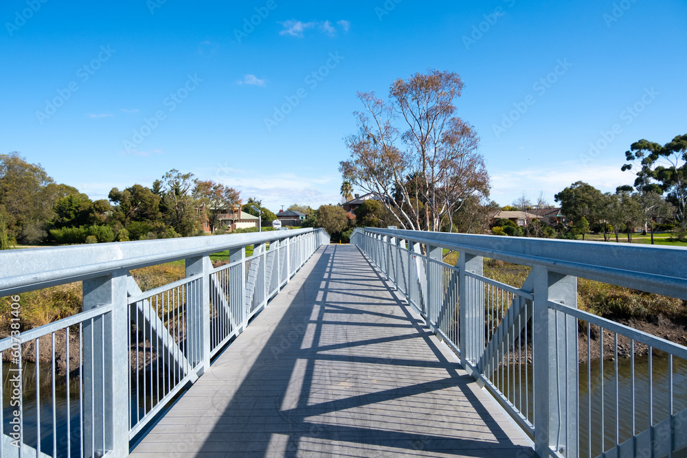 View from a footbridge at wetlands leads to some residential houses in a Melbourne suburb. Skeleton Creek, VIC Australia. Concept of the beautiful environment and livable suburban neighborhood.