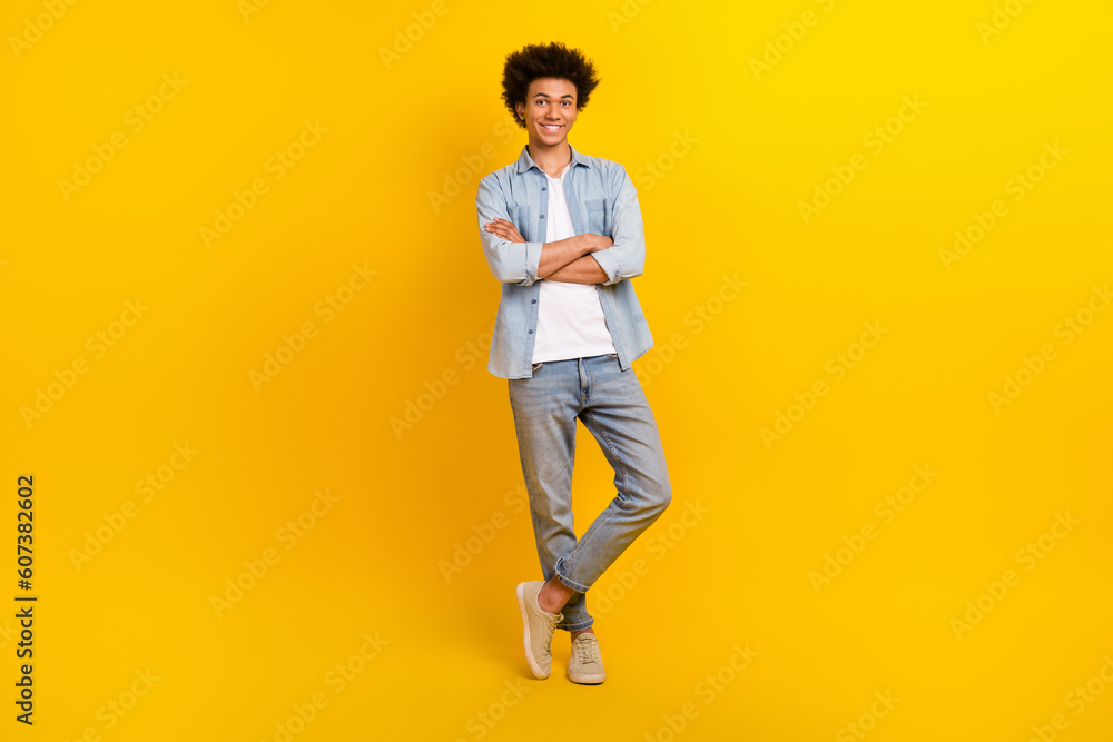 Full length photo of positive successful person crossed arms posing isolated on yellow color background Full length photo of positive successful person crossed arms posing isolated on yellow color background