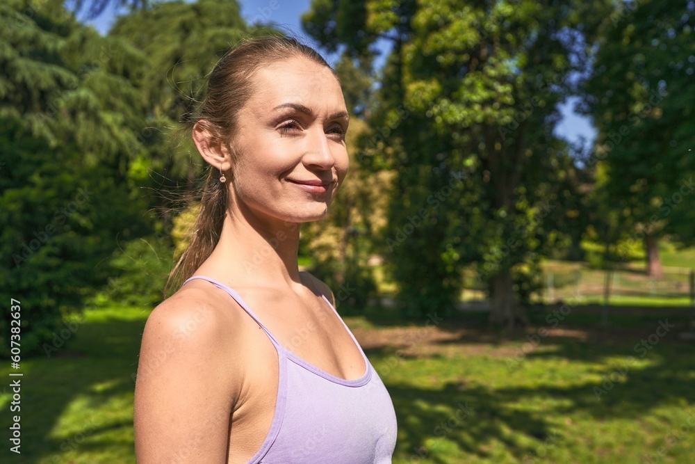 In her sportswear, a woman finds her stride amidst the park's greenery. In her sportswear, a woman finds her stride amidst the park's greenery.