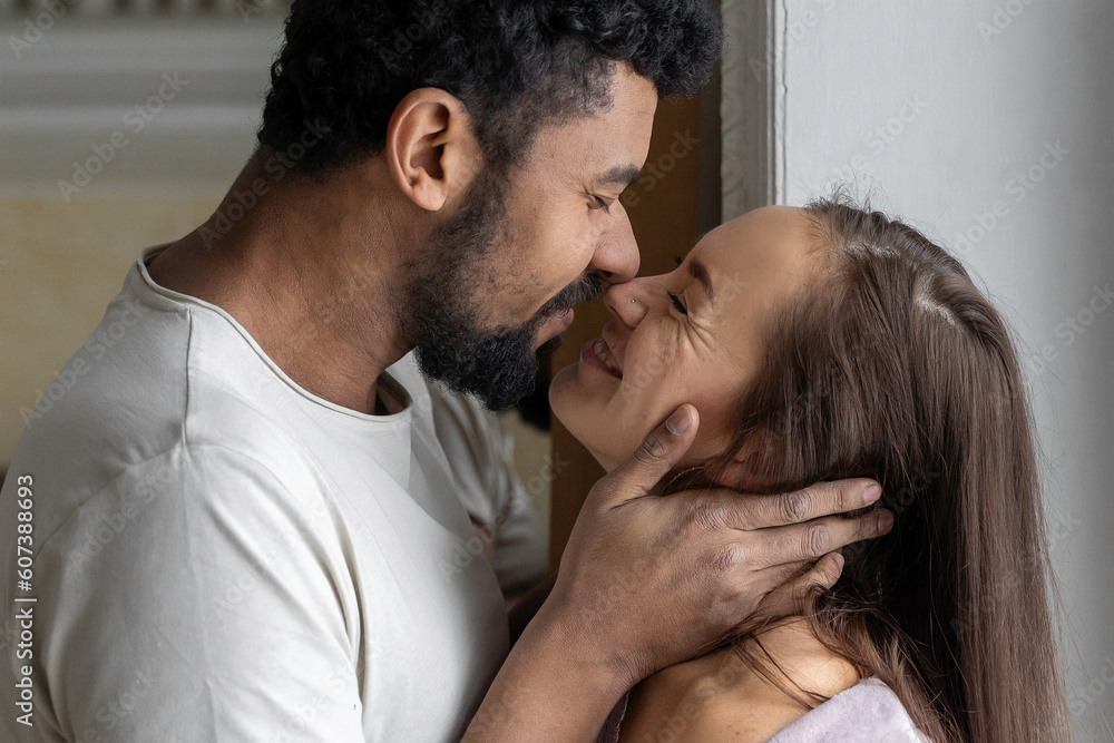 Fototapeta premium Multiethnic American couple embracing at home.