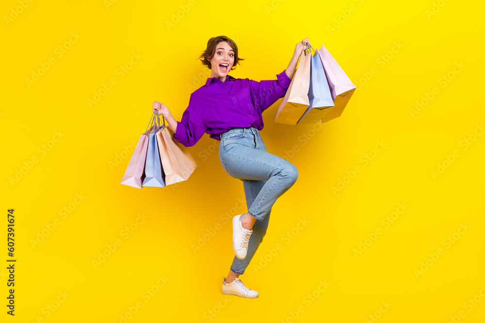 Full length body photo of young carefree addicted shopaholic woman wear formal clothes hold bags boutique isolated on yellow background - obrazy, fototapety, plakaty 