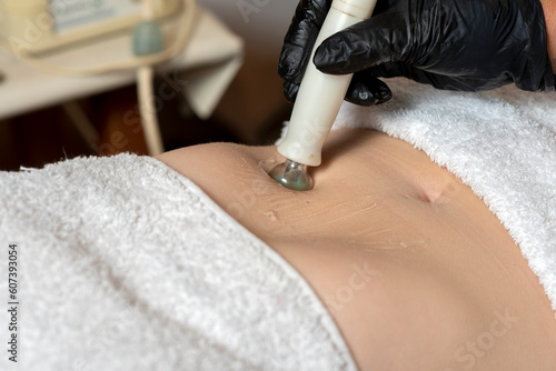 aesthetic treatment on the body of a woman in aesthetic center radio frequency and high frequency technique for health and beauty photo