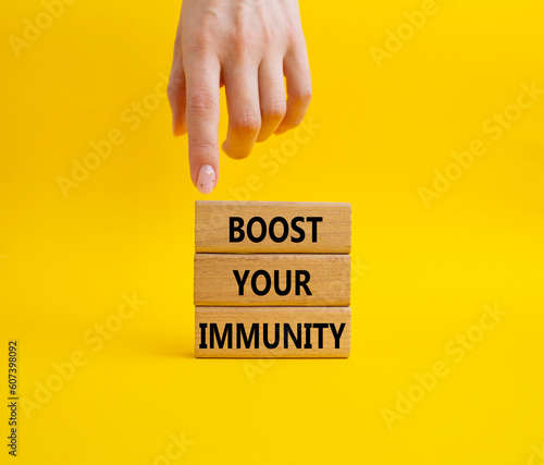 Boost your immunity symbol. Concept word Boost your immunity on wooden blocks. Doctor hand. Beautiful yellow background. Helthcare and Boost your immunity concept. Copy space