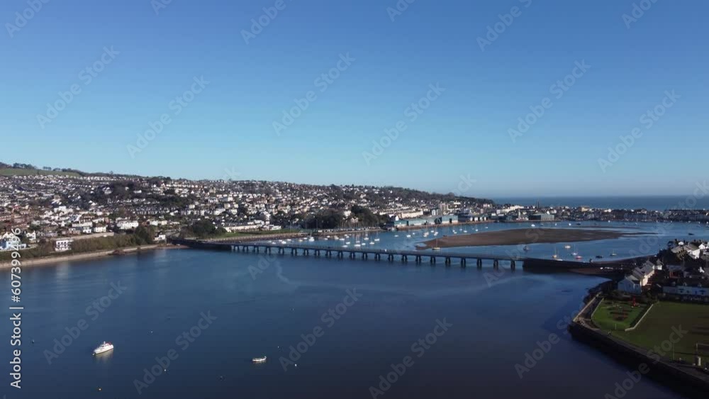 Teignmouth, South Devon, England: DRONE VIEWS: The drone flies towards the River Teign bridge, Teignmouth Docks & the town of Teignmouth; a railway train heads from Teignmouth to Newton Abbot. Teignmouth, South Devon, England: DRONE VIEWS: The drone flies towards the River Teign bridge, Teignmouth Docks & the town of Teignmouth; a railway train heads from Teignmouth to Newton Abbot.