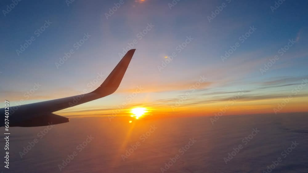 Airplane wing in flight against the backdrop of sunset and clouds Airplane wing in flight against the backdrop of sunset and clouds