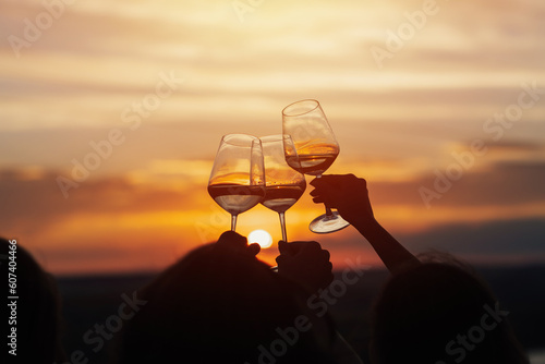 Obraz na płótnie A group of girlfriends raise a toast with glasses of white wine on a sunset. Close shot.
w salonie