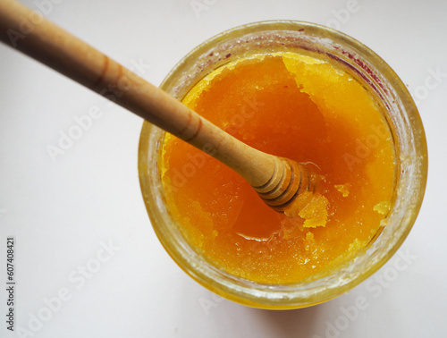 фотографія Crystallized honey in a glass jar. Focused in solidified honey.