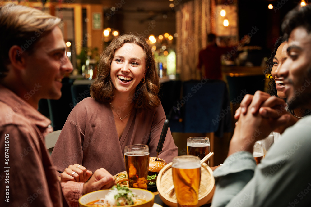 Happy young multiracial group of friends in casual clothing laughing and enjoying dinner at bar Happy young multiracial group of friends in casual clothing laughing and enjoying dinner at bar