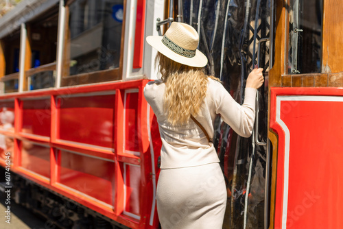 Photography Beautiful young girl tourist in a hat poses in front of tram at popular Istiklal