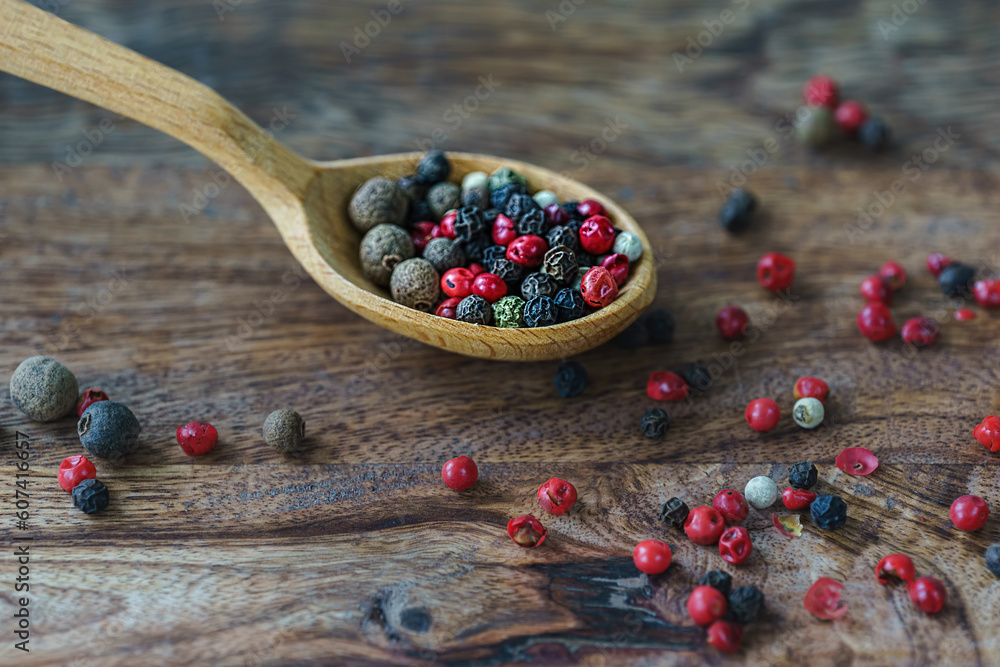 mix of spice peppers in a wooden spoon on a wooden background in rustic style mix of spice peppers in a wooden spoon on a wooden background in rustic style