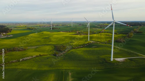 Windmill generator large wind turbines with blades in field with growing crops. Electricity, ecological saving and alternative power source