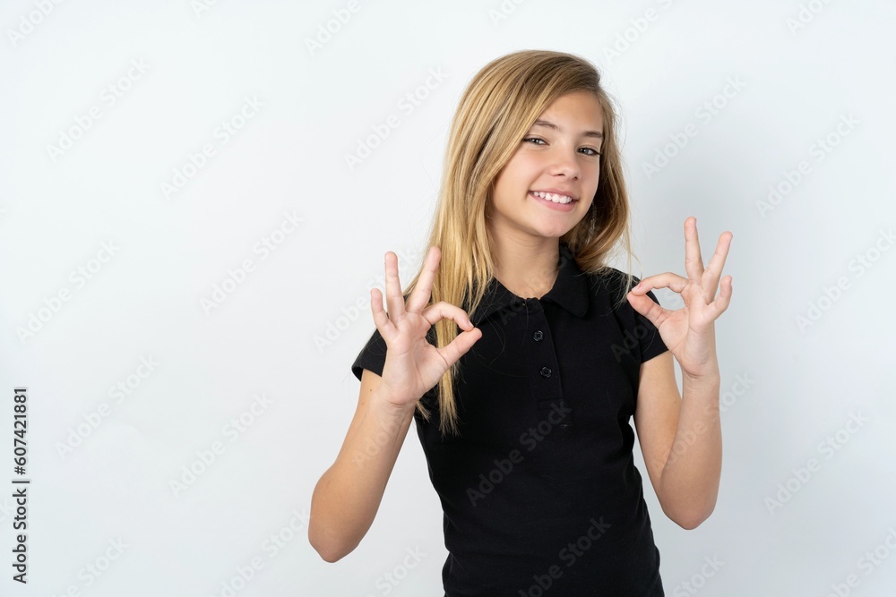 beautiful teen girl wearing black dress over white studio background showing both hands with fingers in OK sign. Approval or recommending concept beautiful teen girl wearing black dress over white studio background showing both hands with fingers in OK sign. Approval or recommending concept