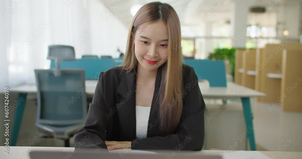 Confident and cheerful asian business woman working on laptop computer in office. Focused successful female freelancer entrepreneur making data analysis on project paperwork planning success strategy. Confident and cheerful asian business woman working on laptop computer in office. Focused successful female freelancer entrepreneur making data analysis on project paperwork planning success strategy.