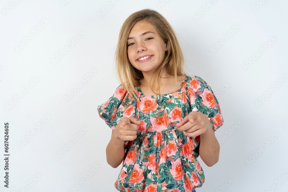 beautiful teen girl wearing flowered dress over white studio background pointing fingers to camera with happy and funny face. Good energy and vibes. beautiful teen girl wearing flowered dress over white studio background pointing fingers to camera with happy and funny face. Good energy and vibes.