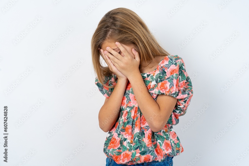 Sad beautiful teen girl wearing flowered dress over white studio desperate and depressed with tears on her eyes suffering pain and depression in sadness facial expression and emotion concept Sad beautiful teen girl wearing flowered dress over white studio desperate and depressed with tears on her eyes suffering pain and depression in sadness facial expression and emotion concept