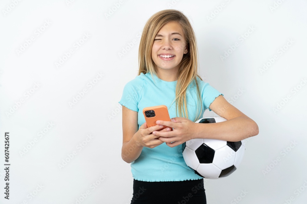 beautiful caucasian teen girl wearing sportswear holding a football ball over white wall taking a selfie celebrating success beautiful caucasian teen girl wearing sportswear holding a football ball over white wall taking a selfie celebrating success