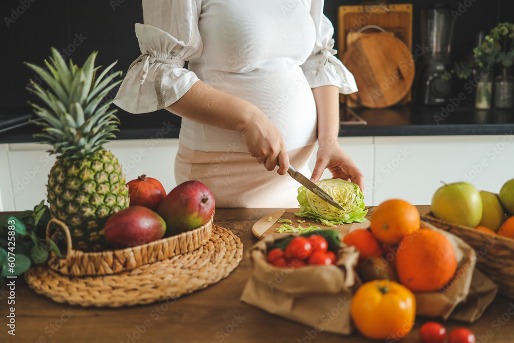 Pregnant woman making salad in her kitchen, healthcare Pregnant woman making salad in her kitchen, healthcare