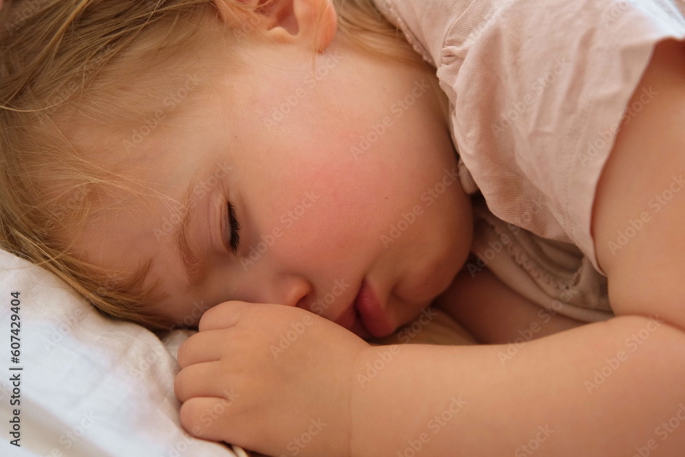 Peaceful adorable baby sleeping on his bed at home. Sleeping newborn baby concept. One year old baby girl sleeps peaceful at domestic room interior background. Serene dream. Cute Face Close Up Peaceful adorable baby sleeping on his bed at home. Sleeping newborn baby concept. One year old baby girl sleeps peaceful at domestic room interior background. Serene dream. Cute Face Close Up
