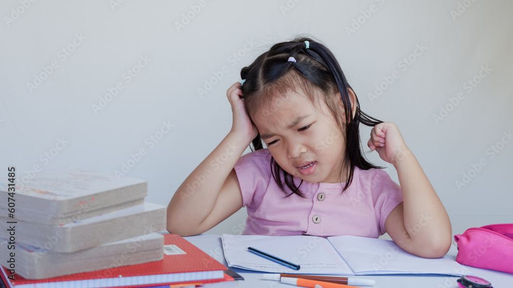 young asian girl is studying so hard. concept of brainstorming, thinking hard, failure, difficult decision, doing difficult task. young asian girl is studying so hard. concept of brainstorming, thinking hard, failure, difficult decision, doing difficult task.
