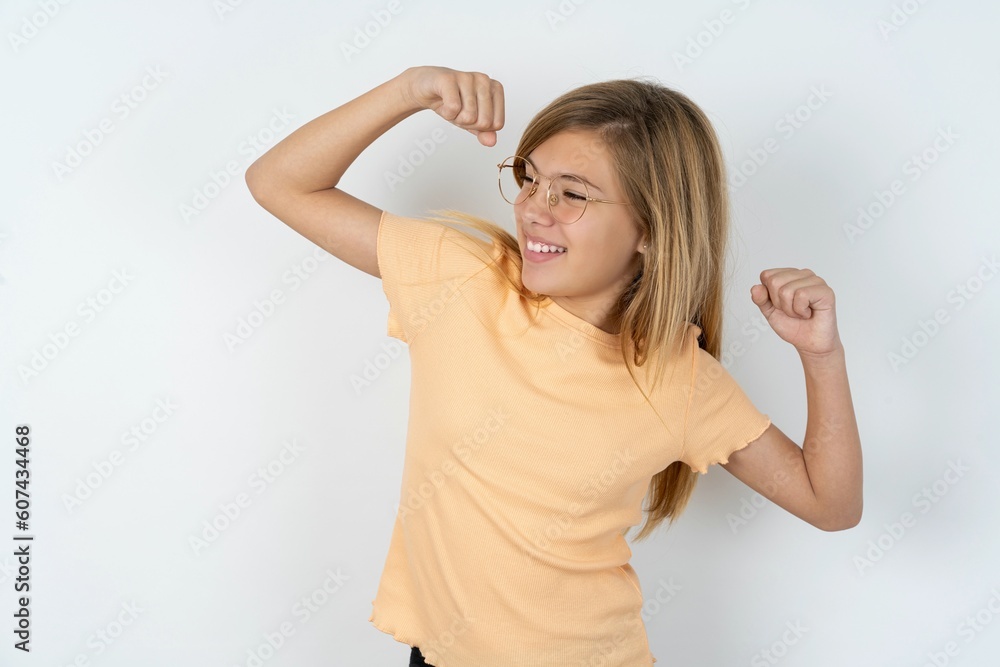 Yes I am winner. Portrait of charming delighted and excited beautiful caucasian teen girl wearing orange T-shirt raising up fist in triumph and victory smiling achieving success grinning from delight. Yes I am winner. Portrait of charming delighted and excited beautiful caucasian teen girl wearing orange T-shirt raising up fist in triumph and victory smiling achieving success grinning from delight.