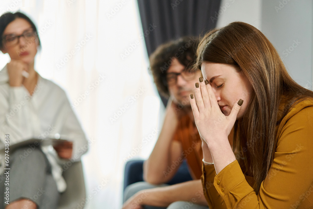 Portrait of sorrow upset woman covers face with hands feeling despair on therapy session with psychotherapist. Marital Psychotherapy Portrait of sorrow upset woman covers face with hands feeling despair on therapy session with psychotherapist. Marital Psychotherapy