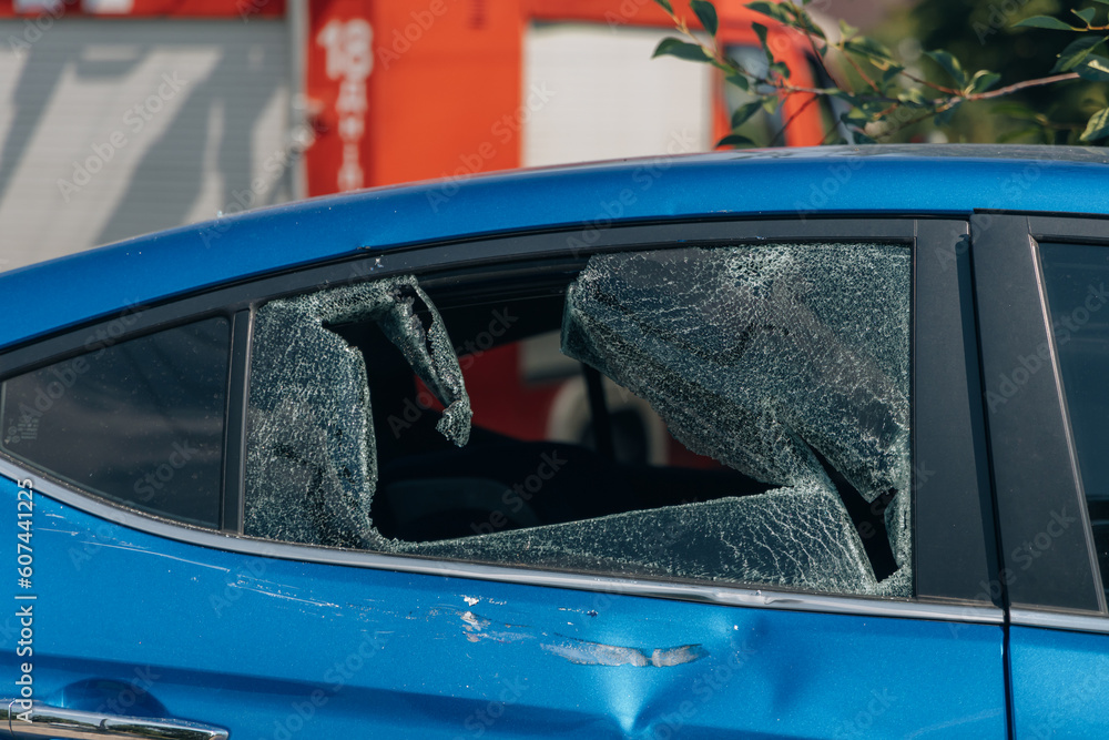 Fototapeta premium Broken windshield and side glass in the car. Close-up. The blue color of the car. Problem. Glass replacement. accident