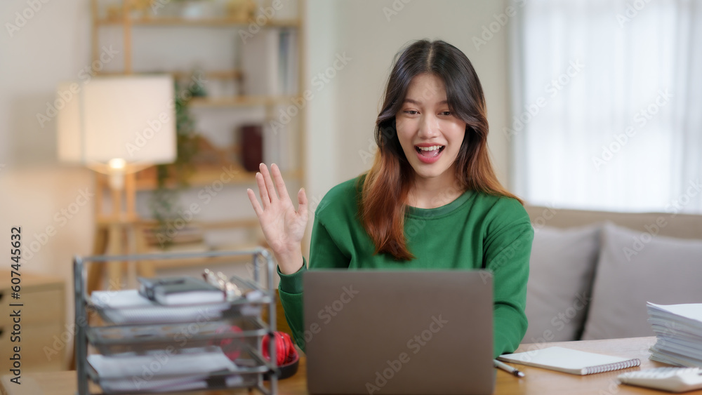 Happy young Asian woman wear headphones having video call on laptop computer at home. Young asia female chatting online in social networks, having fun. Happy young Asian woman wear headphones having video call on laptop computer at home. Young asia female chatting online in social networks, having fun.
