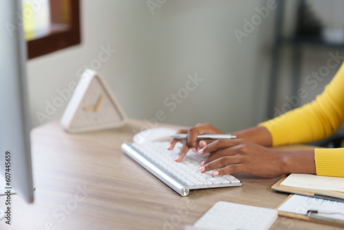 Close-up of hand of businesswoman working using laptop computer to record and print information for a marketing plan analyze the balance sheet report quarterly financial statement.