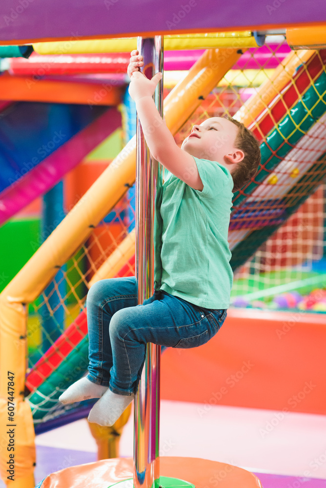 Fototapeta premium boy on the playground with colored plastic balls
