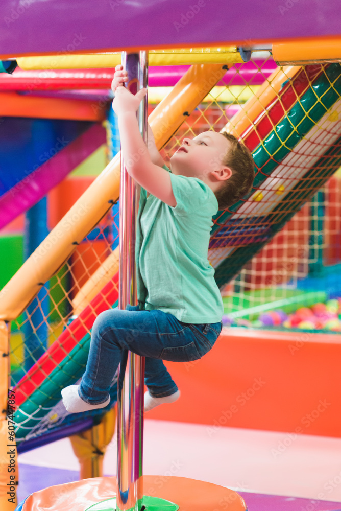 Fototapeta premium boy on the playground with colored plastic balls