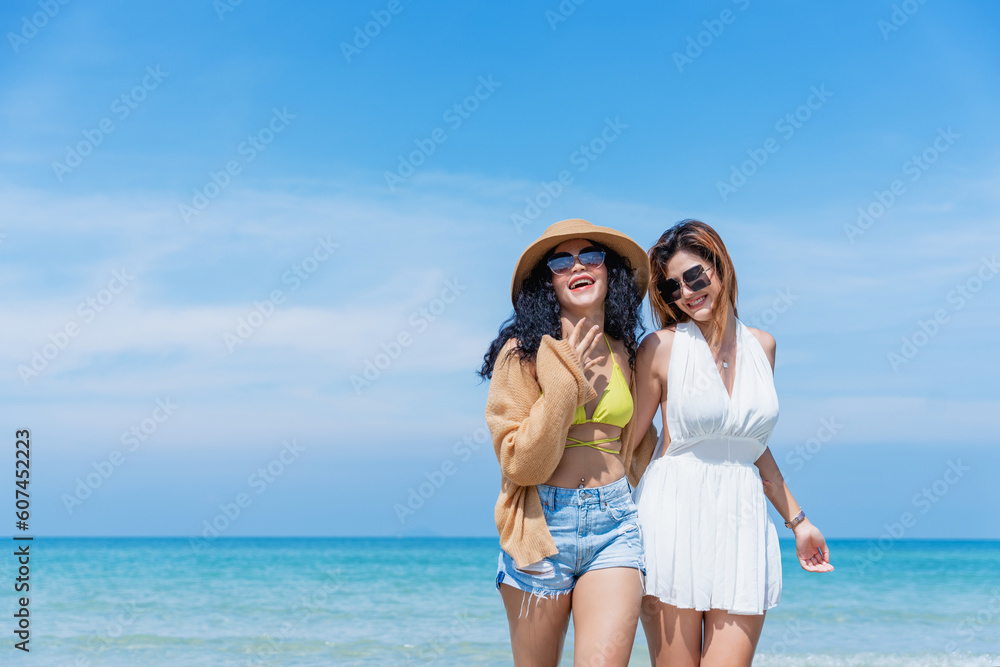 Free and happy young women enjoying a walk along the beach. Summer vacation and holiday concept. Free and happy young women enjoying a walk along the beach. Summer vacation and holiday concept.