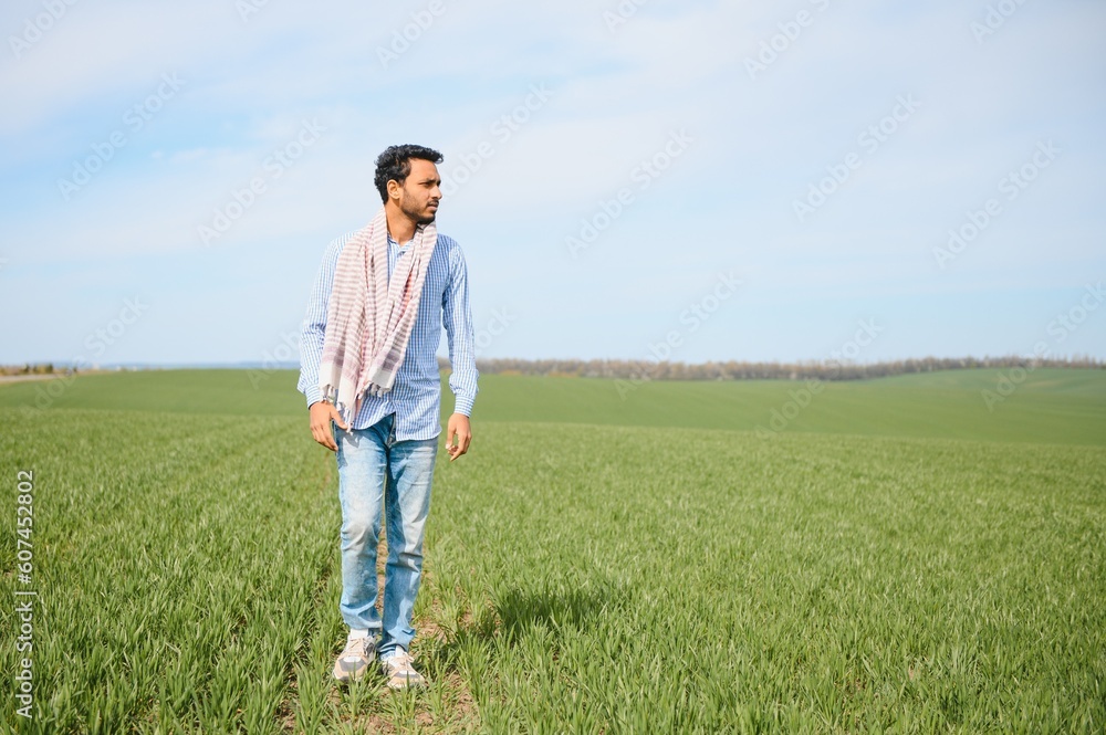 Portrait of young Indian Farmer wearing formal dress in green paddy field.