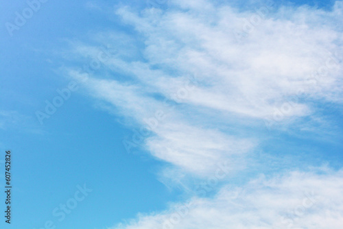 Sky. Blue sky with white clouds background. Curly clouds on a sunny summer day. Light cloudy. Good weather. Simple background sky for summer poster. Summer mock up. Soft focus.