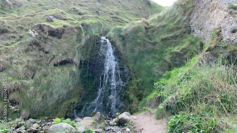 A small waterfall with a lot of moss and stones around A small waterfall with a lot of moss and stones around