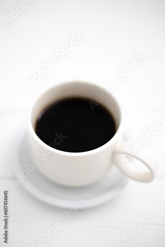 A cup of black aromatic coffee on a wooden background. Coffee for breakfast in a white cup