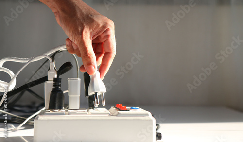 Fotografie Man's hand is plugging the electrical plug into the socket