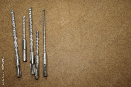 Selection of masonry drill bits on the brown MDF board