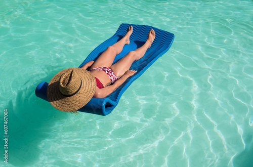 Middle-aged woman lounging lying on a mattress in the water