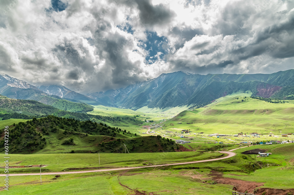 Green mountain valley. Gloomy cloudy sky in the mountains. Kyrgyz Ala-Tau, Chon-Kurchak gorge.