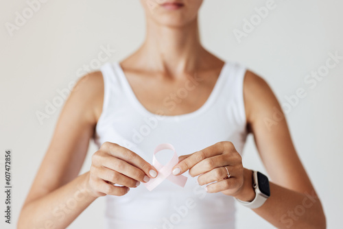 Woman with pink ribbon symbol of breast cancer awareness month.