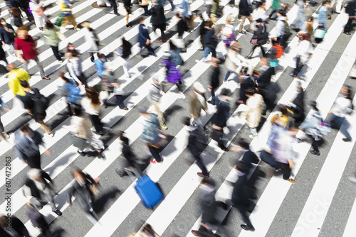 picture with intentional motion blur of crowds of people crossing a city street in Tokyo, Japan