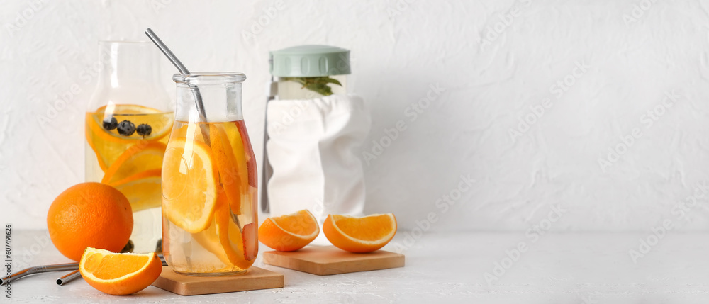 Bottle of orange infused water on table. Banner for design Bottle of orange infused water on table. Banner for design