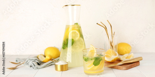 Glassware of fresh lemonade on light background